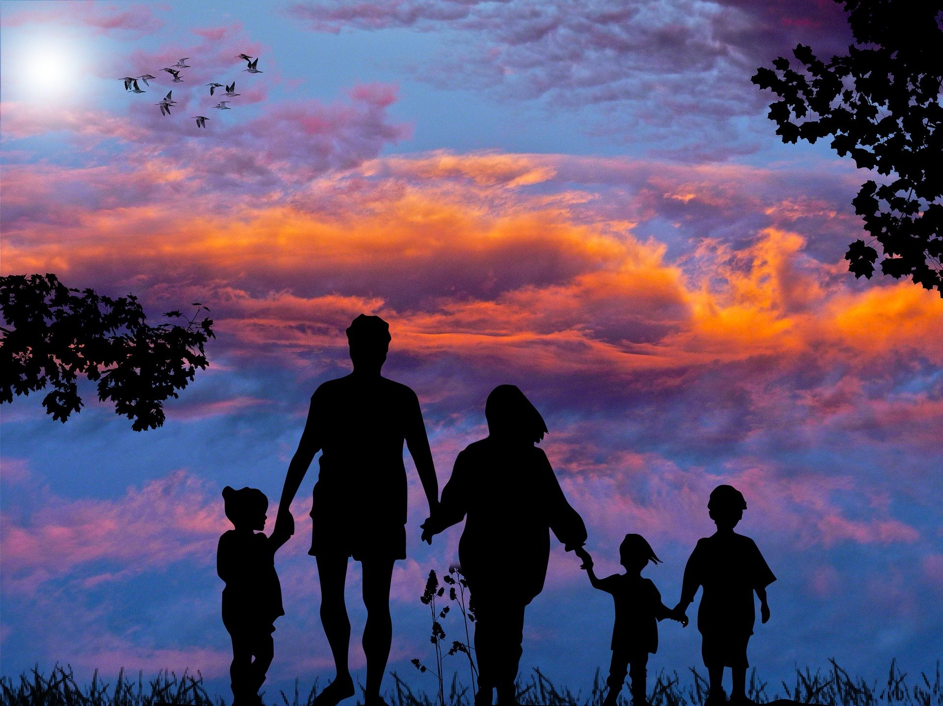 Eine Familie läuft Hand in Hand Richtung Sonnenuntergang